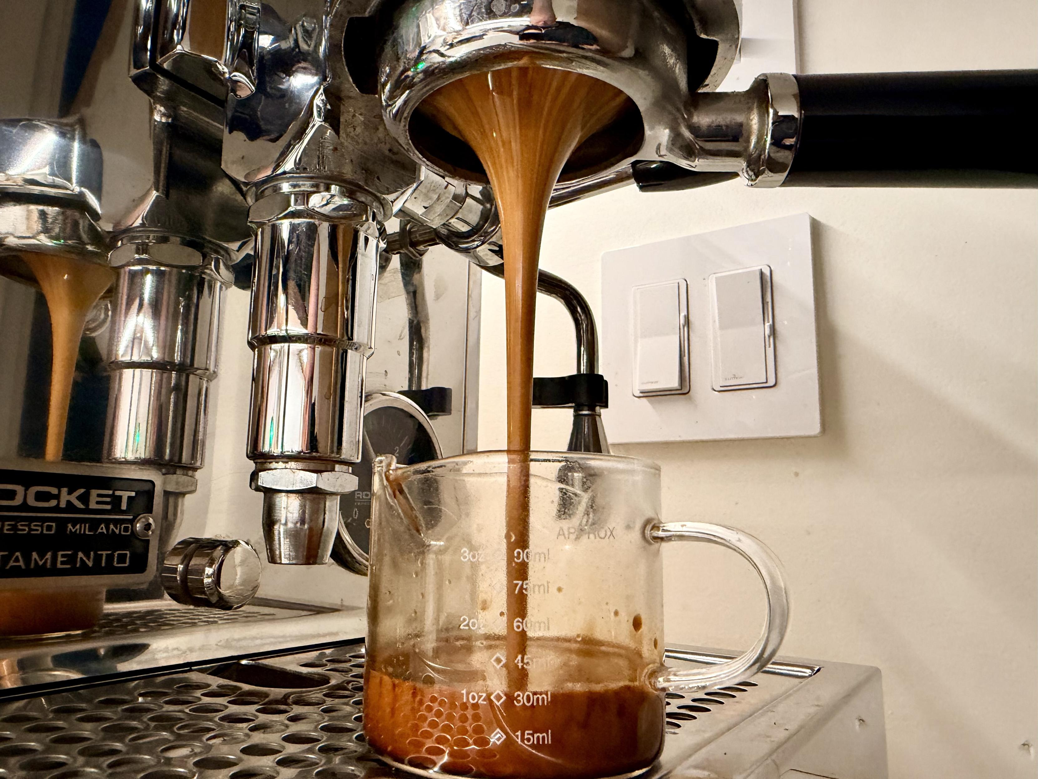A shot of espresso mid extraction.