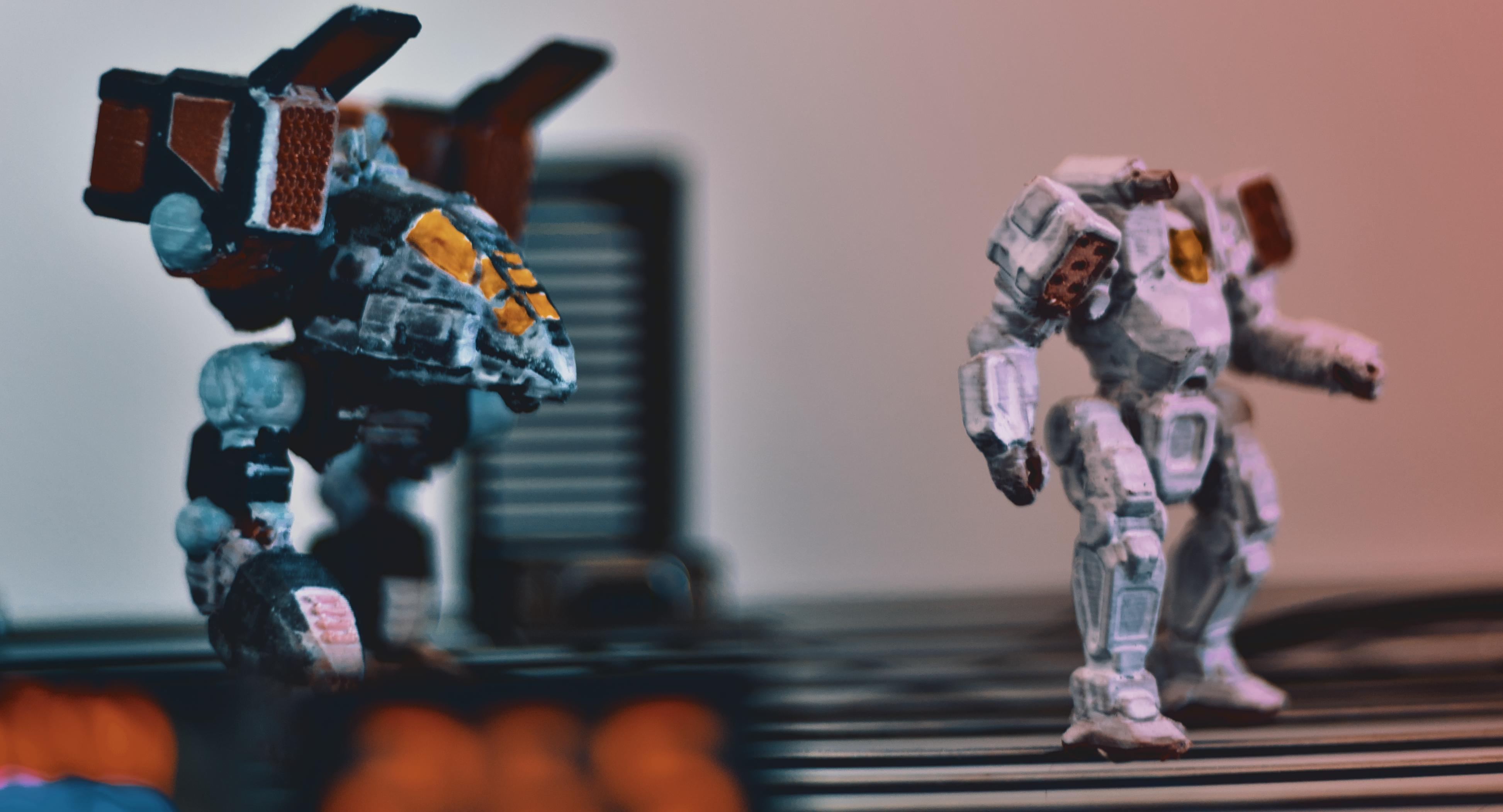close, wide action shot of fighting robot figures facing right