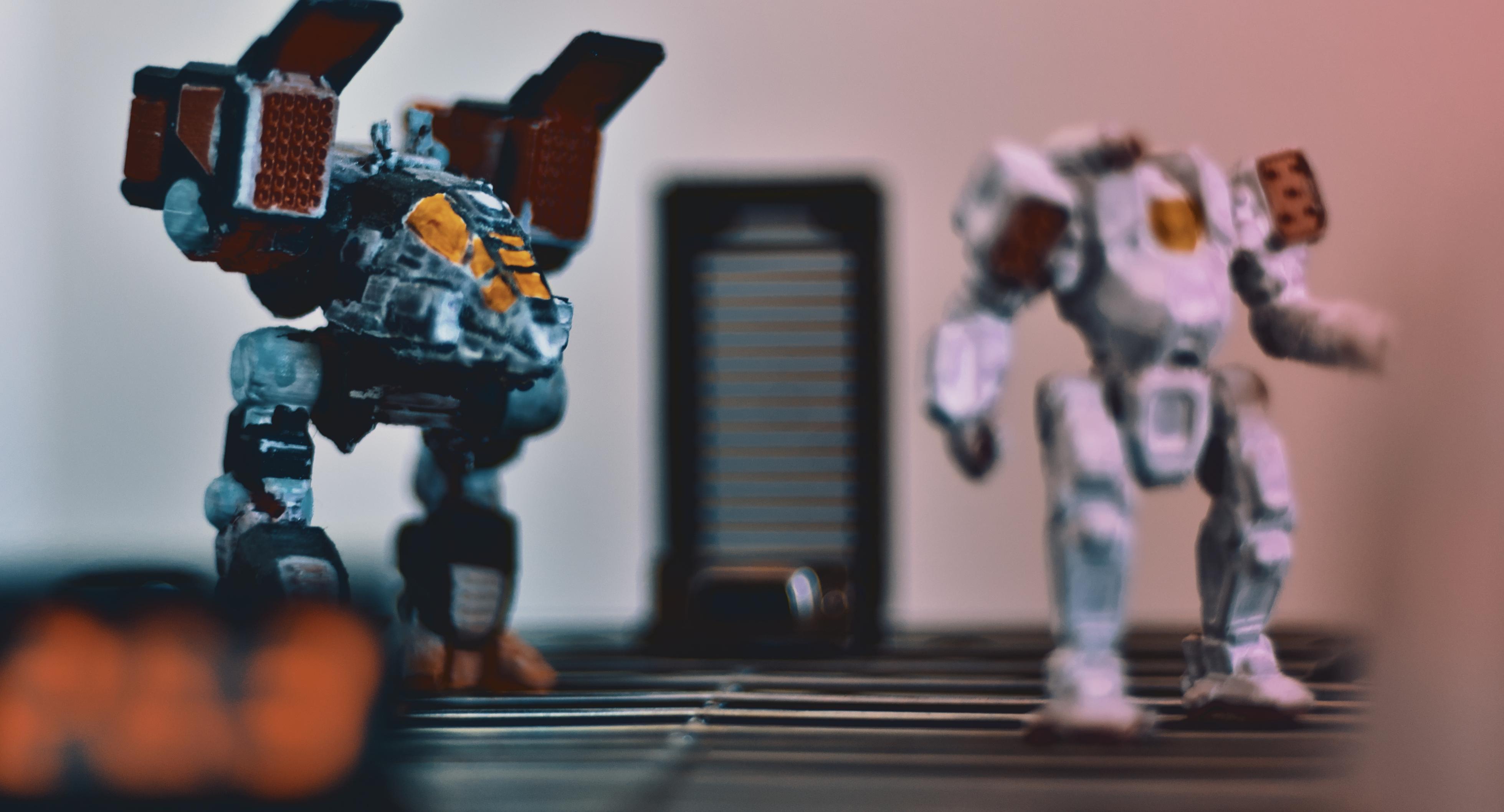 close, wide action shot of fighting robot figures facing right